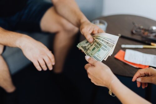 man handing money to person