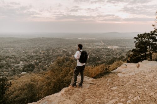 man standing alone on edge of cliff